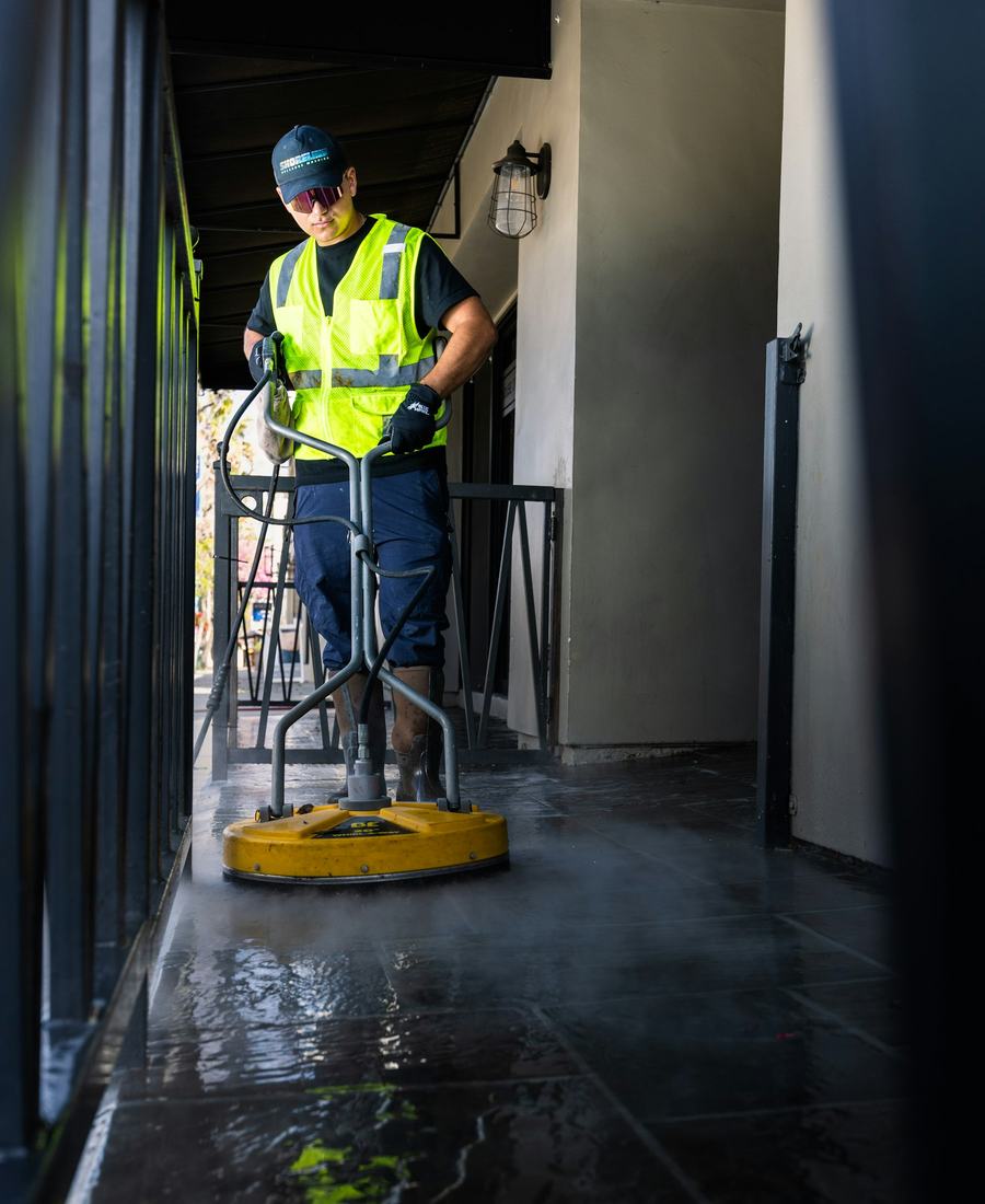 A Torrent technician running a surface cleaner over a tiled entryway